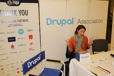 Megan Sanicki sits at Drupal Association table in DrupalCon Portland
