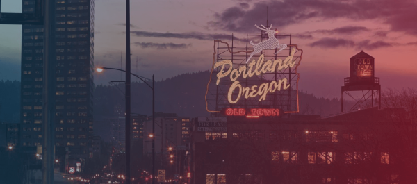 This image serves as the header for DrupalCon Portland, showcasing the cityscape, enhanced by an overlay of a gradient blending blue and pink hues.
